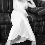 Young woman in white dress sitting on a sofa