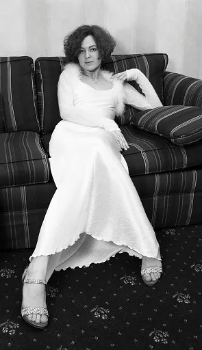 Young woman in white dress sitting on a sofa