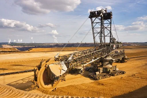 Giant bucket wheel excavator Excavator is taking away the layers of ground before digging the brown coal. Largest open pit lignite mine in Europe. Power stations at horizon transform the coal to electricity.
