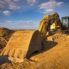 Dirty yellow excavator in a sunny summer day