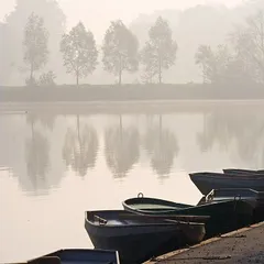 Rowing boats on the lakeside in a misty morning