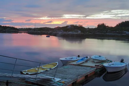 Floating pier with a few boats in twilight